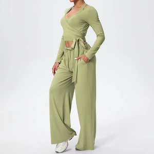 Détail du haut de yoga cache-cœur vert sauge avec nœud et pantalon large assorti