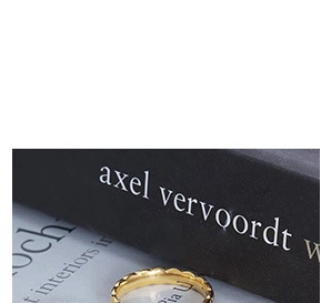 Foto macro de anillo de acero inoxidable dorado con elegante textura geométrica ondulada