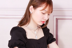 Detail of layered pearl necklace with textured silver heart pendants and matching earrings
