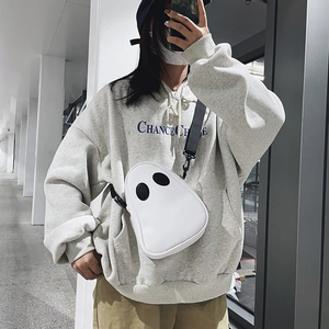 Detail of cute white ghost crossbody bag featuring black eye patches and nylon strap