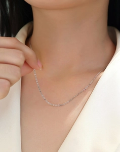 Detailed view of elegant minimalist silver sterling chain necklace on white suit background