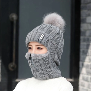 Détail du bonnet d'hiver en tricot gris avec masque à fermeture éclair et pompon doux