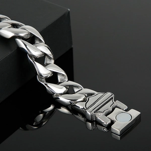 Close-up of stainless steel Cuban link bracelet with magnetic shield clasp and heavy texture