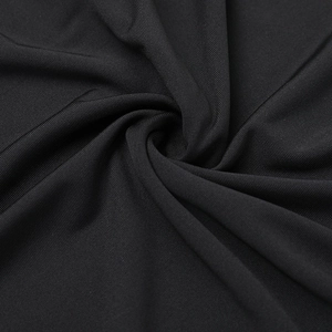 Détail du tissu en maille noire montrant la texture premium et le drapé du vêtement