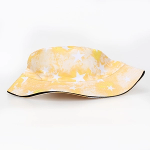 Close-up of yellow tie-dye bucket hat featuring white star patterns and fabric texture
