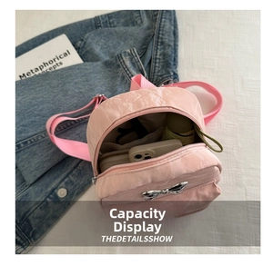 Mini zaino rosa con fiocco metallico che mostra la capacità interna e gli oggetti