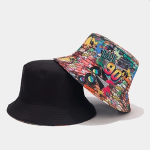 Detail view of reversible bucket hat showing vivid 90s graffiti print and solid black canvas