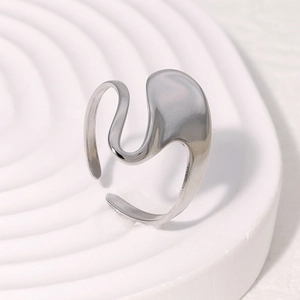 Detail of minimalist fluid silver ring with irregular liquid metal texture on white tray