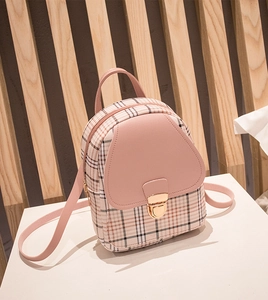 Detailed side view of a pink checkered mini backpack with heart-shaped flap on white pedestal
