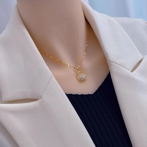 Elegant gold tulip necklace with white cat eye opal teardrop pendant and zircon crystals