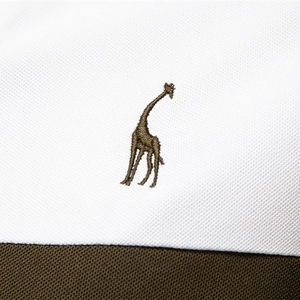 White piqué polo shirt with olive green contrast collar and giraffe embroidery detail
