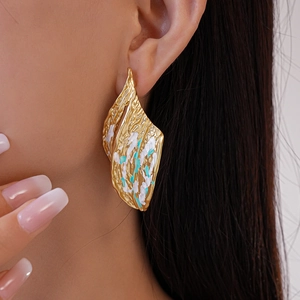 Irregular gold leaf earrings with turquoise and white marble textures on model