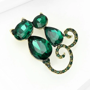 Detailed macro view of the gold cat brooch featuring faceted green crystals and small rhinestones