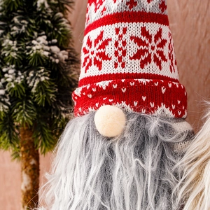 Close-up of a Christmas gnome bottle topper with red knit snowflake hat and gray fur beard