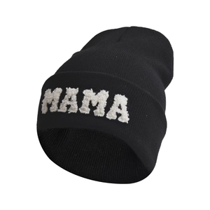 Black knit beanie featuring white fuzzy MAMA letter patches on folded cuff in a soft texture