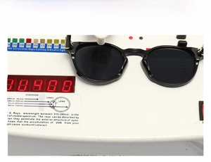 Detail view of round sunglasses showing UV protection testing on professional equipment