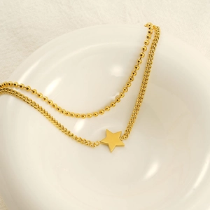 Collier double rang en acier inoxydable doré avec pendentif étoile sur bol céramique