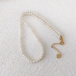 Detail view of natural freshwater pearls with golden adjustable clasp and extension chain