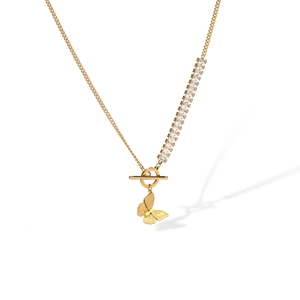 Macro detail of gold butterfly necklace with zircon stones and elegant toggle clasp