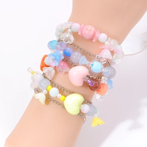 Detalle de pulseras de corazón con cuentas de colores pastel en capas en la muñeca