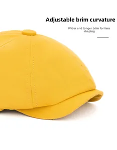 Detail of a yellow newsboy cap showing foldable wide brim for facial contouring