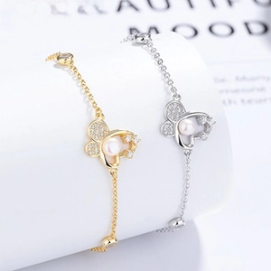 Detailed shot of butterfly pearl bracelets in gold and silver with zircon accents