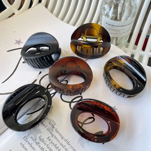 Detail shot of large oval claw clips in glossy black and tortoise shell patterns