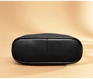 Detail view of the black genuine leather handbag bottom featuring premium lychee grain texture