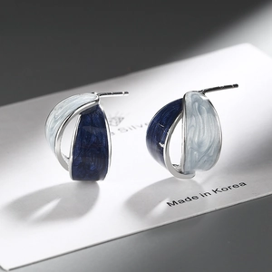 French style silver earrings with blue enamel swirls on a professional jewelry card