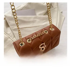 Detail of brown quilted leather bag with gold SS logo and chain strap eyelets