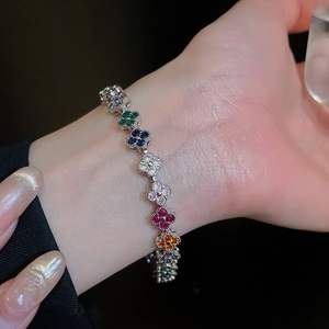 Macro shot of silver bracelet featuring multi-colored zircon stones in clover patterns