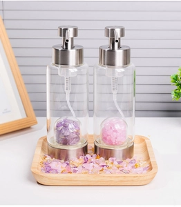 Detail of soap dispensers with silver pumps and internal purple and pink crystal stones