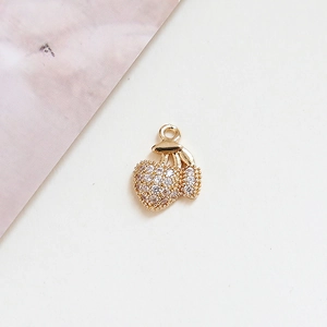 Macro shot of gold-plated cherry pendant with clear zircons for DIY jewelry making