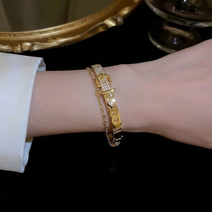 Gold plated buckle bracelet with cat eye stone and cubic zirconia in a sleek design