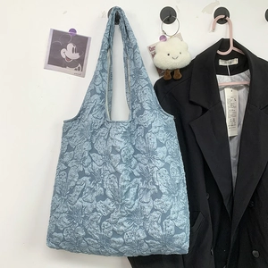Détail du sac cabas bleu clair avec texture jacquard florale 3D et poignée robuste