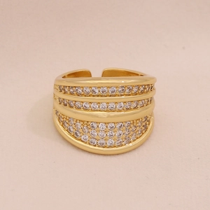 Macro detail of gold striped open ring featuring multiple rows of pave white zircons
