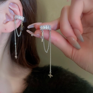 Macro detail of silver star tassel ear cuff with sparkling zircon fringe on a model