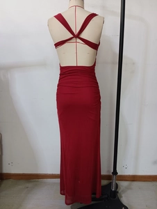 Detail of red backless dress with crossover straps and draped ruched fish tail design