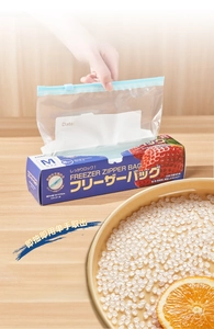 Single hand extracting an M-size sliding zipper freezer bag from its retail box
