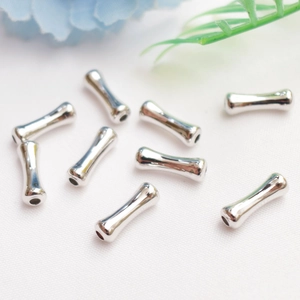 Macro detail of silver bamboo-style bead spacers for DIY jewelry making