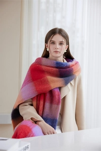 Close-up of thick winter scarf with multi-color gradient plaid patterns and soft texture