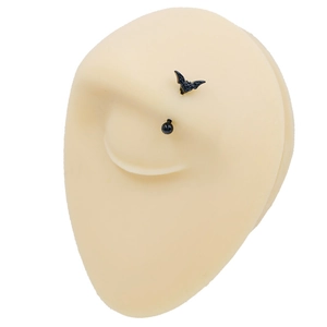 Detail of black stainless steel bat eyebrow ring on a silicone eye model