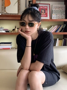 Lunettes de soleil carrées caramel tendance portées par un mannequin en décor vintage