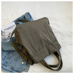 Detail of army green nylon tote bag showing waterproof texture and adjustable strap