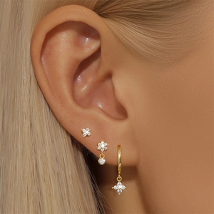 Close-up of gold S925 silver earring set with crystals on female model ear