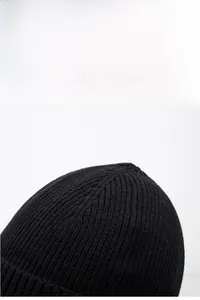 Gros plan du bonnet en maille côtelée noire montrant la texture épaisse et chaude
