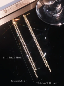 Close-up of gold tassel earrings with rhinestones measuring 11.5cm long and 0.4cm wide