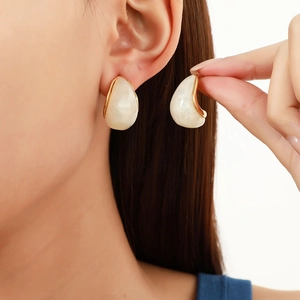 Detailed shot of vintage teardrop earrings with cream resin inlay and gold metal frame