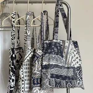 Détail de sacs cabas en lin bohème avec motifs paisley et ethniques sur cintres