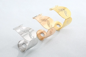 Detail of mustache-shaped open cuff bangles with rhinestones in gold, silver, and rose gold